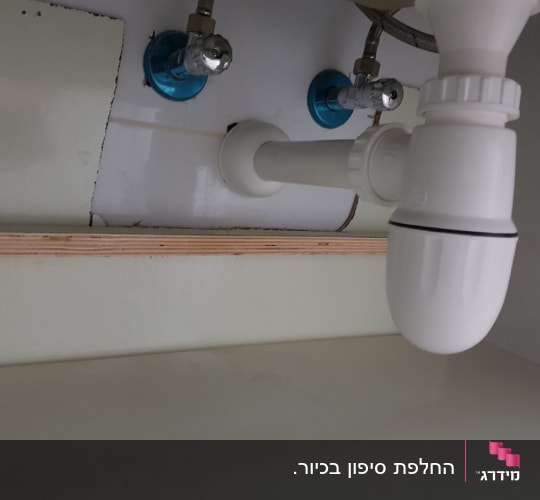 צנרת פלסטיק מתחת לכיור עם ברזים כחולים